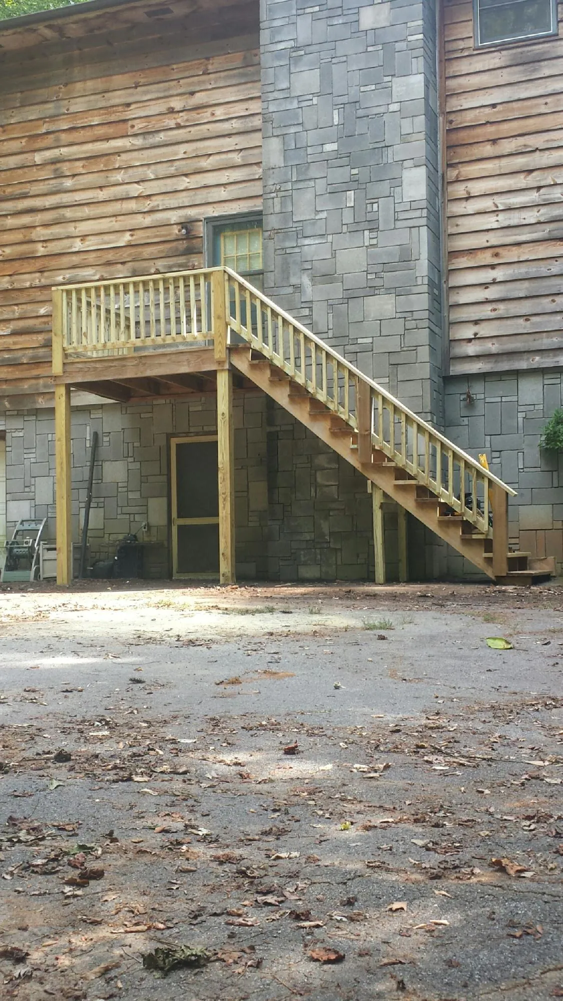 New pressure treated deck and stair landing on a log home in Marianna