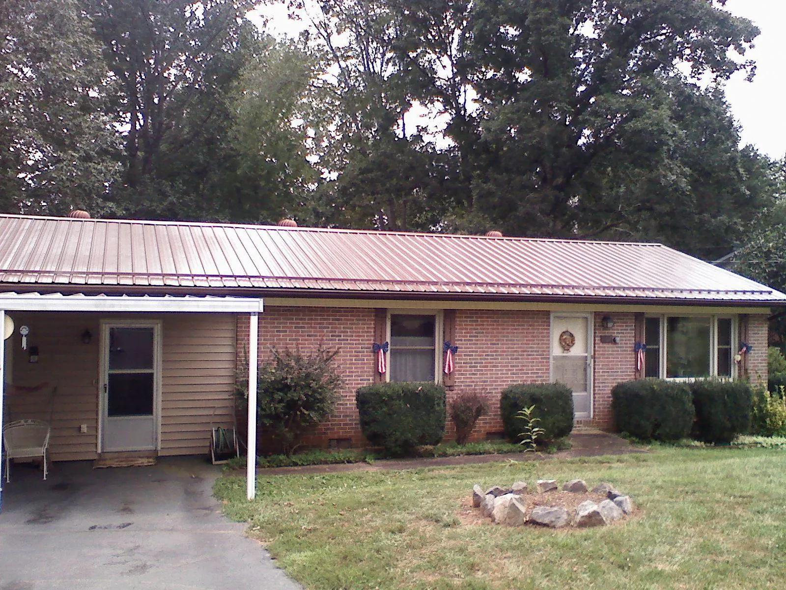 Bronze metal roof and carport on a brick ranch home — Roof Repair work by our crew in Marianna